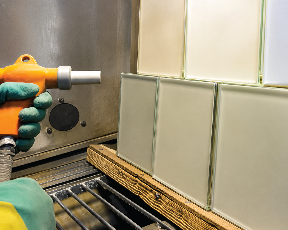 Sand blasting process cleaning metal surface with high-speed abrasive particles